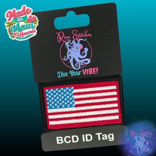 Embroidered BCD Tag Featuring a bold American flag design, in traditional red, white, and blue on Black Webbing. Made for scuba divers by Rinn Stitches in Maui, Hawaii