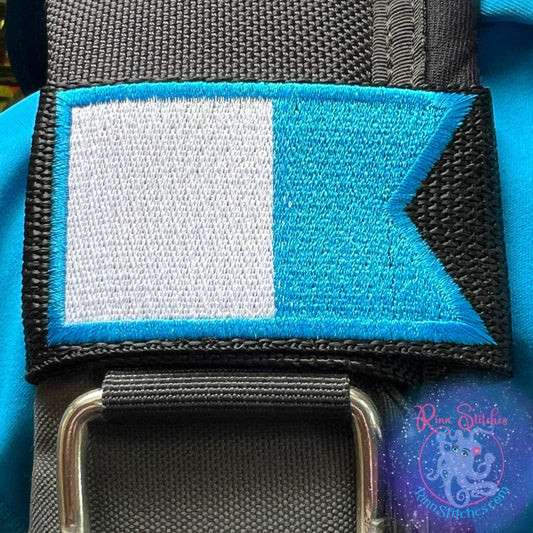Embroidered BCD Tag with the blue and white Alpha International Dive Flag on Black Webbing. Made for scuba divers by Rinn Stitches in Maui, Hawaii