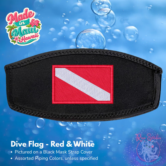 A black mask strap cover featuring an embroidered red and white dive flag patch in the center, shown against a blue water-themed background with bubbles. Made by Rinn Stitches in Maui, Hawaii