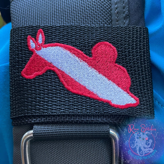 Embroidered BCD Tag with Featuring a nudibranch design in classic dive flag colors on Black Webbing. Made for scuba divers by Rinn Stitches in Maui, Hawaii