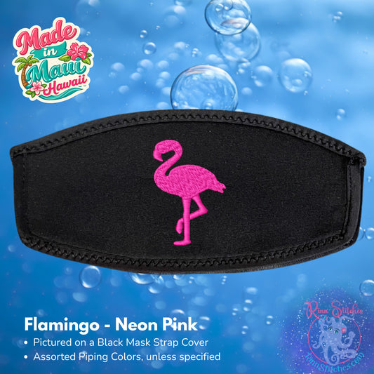 A black neoprene mask strap cover featuring a bright neon pink embroidered flamingo in the center, shown against a blue bubbly underwater-style background with 'Made in Maui Hawaii' by Rinn Stitches