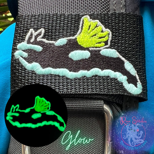 Embroidered BCD Tag with Featuring a gloomy nudibranch with glow-in-the-dark accents that come to life in low light on Black Webbing. Made for scuba divers by Rinn Stitches in Maui, Hawaii