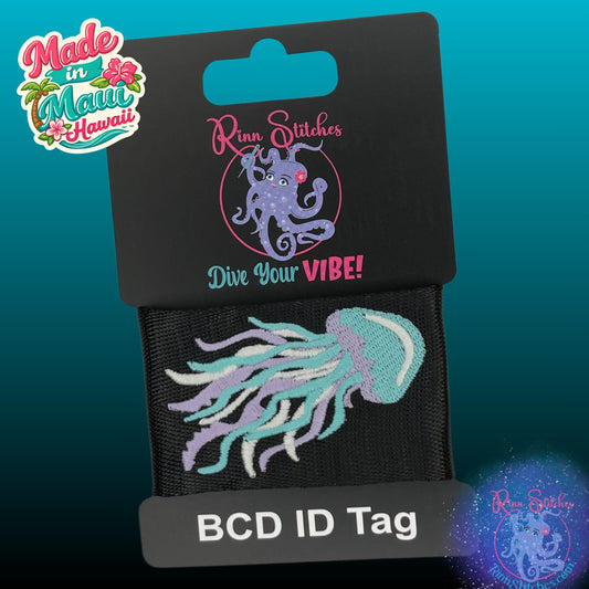 Glow in the dark jellyfish embroidered BCD tag, Adventure Gear Tag featuring glow in the dark purple, white and blue thread on black webbing. Made by Rinn Stitches in Maui, Hawaii