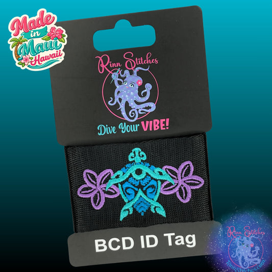 Embroidered BCD Tag on black webbing featuring a tribal style sea turtle and tiki design with plumeria flowers. Made by Rinn Stitches in Maui, Hawaii