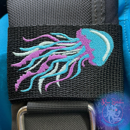 Embroidered BCD Tag Featuring an elegant jellyfish design capturing the fluid motion of drifting through the reef on Black Webbing. Made for scuba divers by Rinn Stitches in Maui, Hawaii