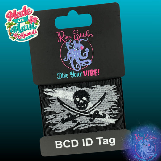 Embroidered BCD Tag with the iconic Jolly Roger Design centered on a Dark Gray and white dive flag on Black Webbing. Made for scuba divers by Rinn Stitches in Maui, Hawaii