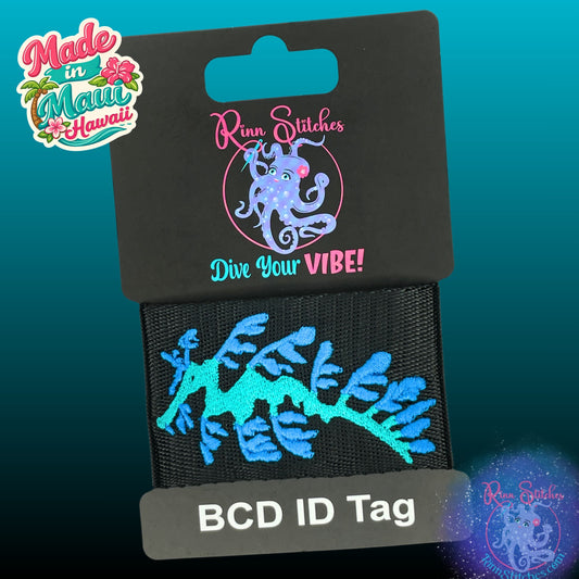Embroidered BCD Tag Featuring a flowing leafy sea dragon design shown in Teal and Ocean on Black Webbing. Made for scuba divers by Rinn Stitches in Maui, Hawaii