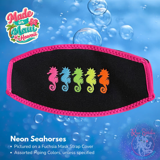 A black neoprene mask strap cover featuring five embroidered neon seahorses in neon pink, blue, neon green, neon yellow, and neon orange. The product is displayed against a blue bubbly background with 'Made in Maui Hawaii' made by Rinn Stitches.