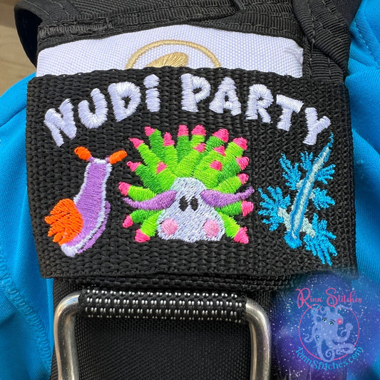 Embroidered BCD Tag Featuring brightly colored nudibranchs with ‘Nudi Party’ text, bringing a fun and lively reef vibe on Black Webbing. Made for scuba divers by Rinn Stitches in Maui, Hawaii