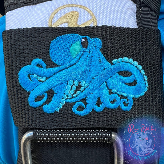 Embroidered BCD Tag Featuring an octopus design with a 3D effect that enhances depth, produced in ocean and teal on Black Webbing. Made for scuba divers by Rinn Stitches in Maui, Hawaii