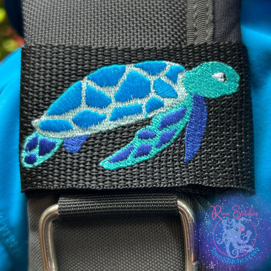 Embroidered BCD Tag featuring a Sea Turtle in Teal and Blues on Black Webbing. Made for scuba divers by Rinn Stitches in Maui, Hawaii