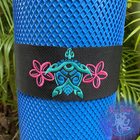 Embroidered scuba tank band featuring a tribal style sea turtle tiki hybrid design with fuchsia plumerias. Made by Rinn Stitches in Maui, Hawaii