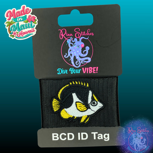 An embroidered BCD ID tag featuring a black and yellow Tinker Butterfly fish design, mounted on a black card labeled 'Rinn Stitches Dive Your VIBE!' and 'BCD ID Tag'. A 'Made in Maui Hawaii' logo is visible in the top left corner.