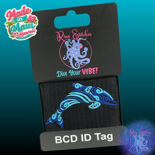 Embroidered BCD Tag Featuring a two-tone tribal dolphin design shown in Blue Abyss and Blue Skies Thread on Black Webbing. Made for scuba divers by Rinn Stitches in Maui, Hawaii