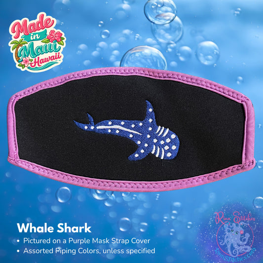 A black neoprene mask strap cover with purple piping featuring an embroidered whale shark design, shown against a blue water-themed background with bubbles. Made in Maui, Hawaii by Rinn Stitches.